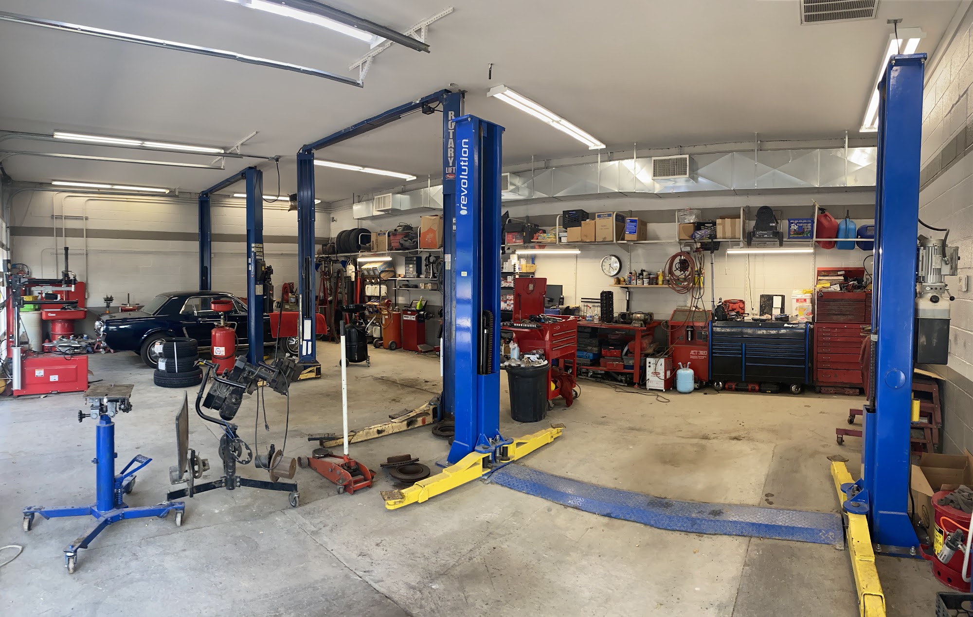 The Checkered Flag Auto Service working bay with blue vehicle lifts and shop equipment